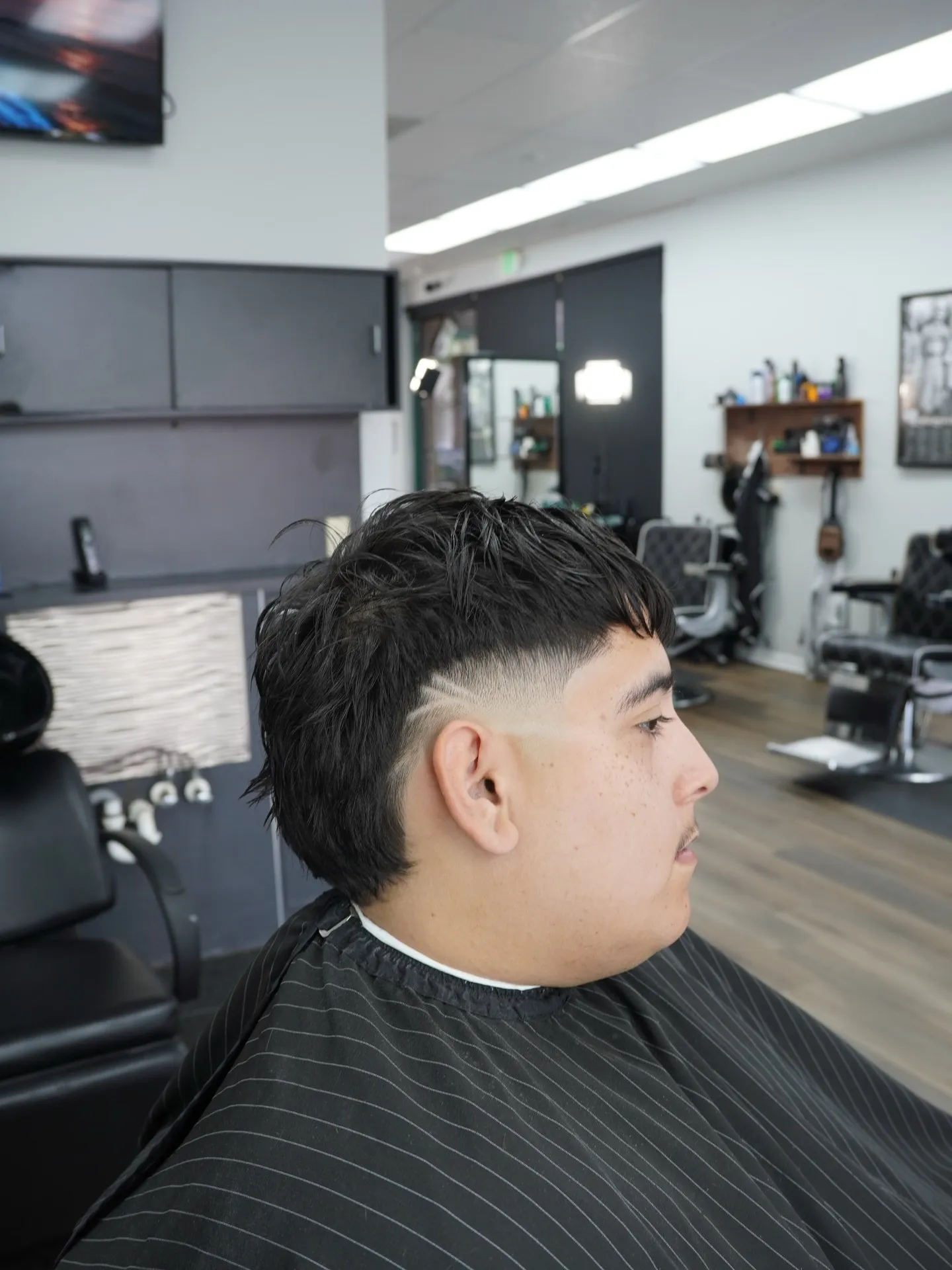 Mid fade with a straight fringe, side profile in the shop