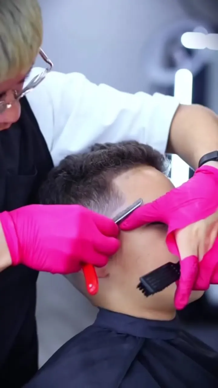 A barber lines up a client's neckline with a straight razor
